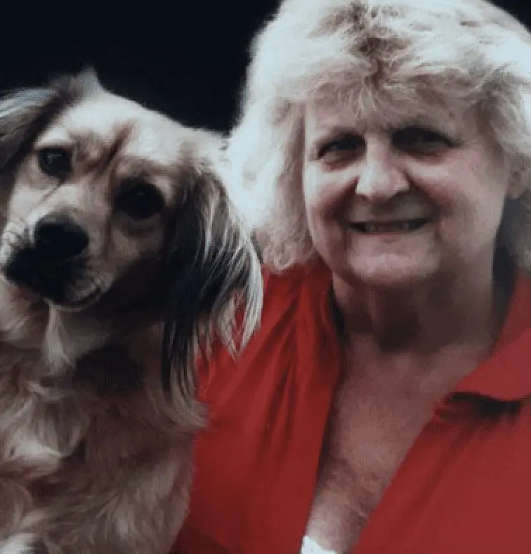A photo of Paws2Rescue team member Cath with a curious looking dog